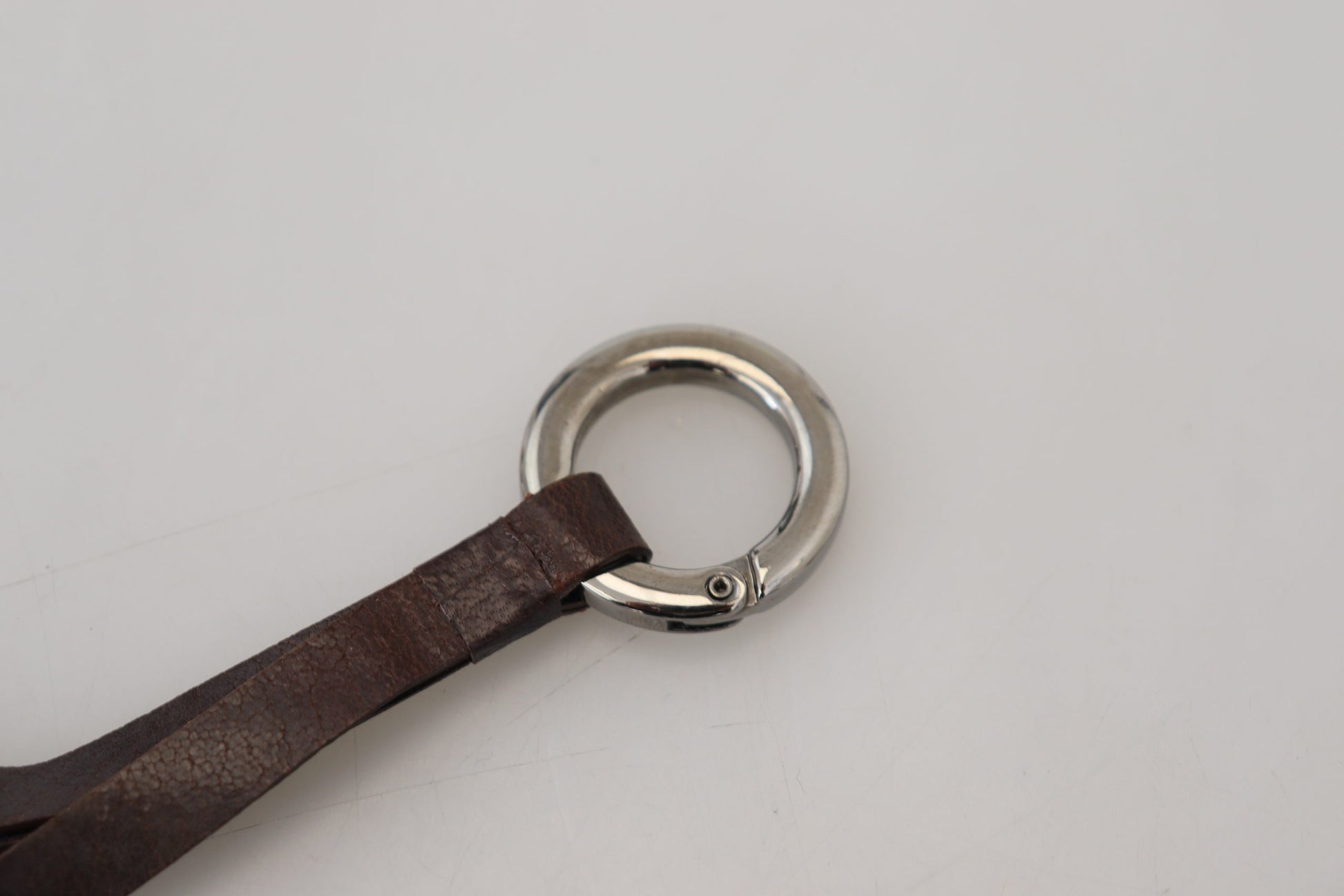 Porte-clés en cuir marron avec métal argenté.