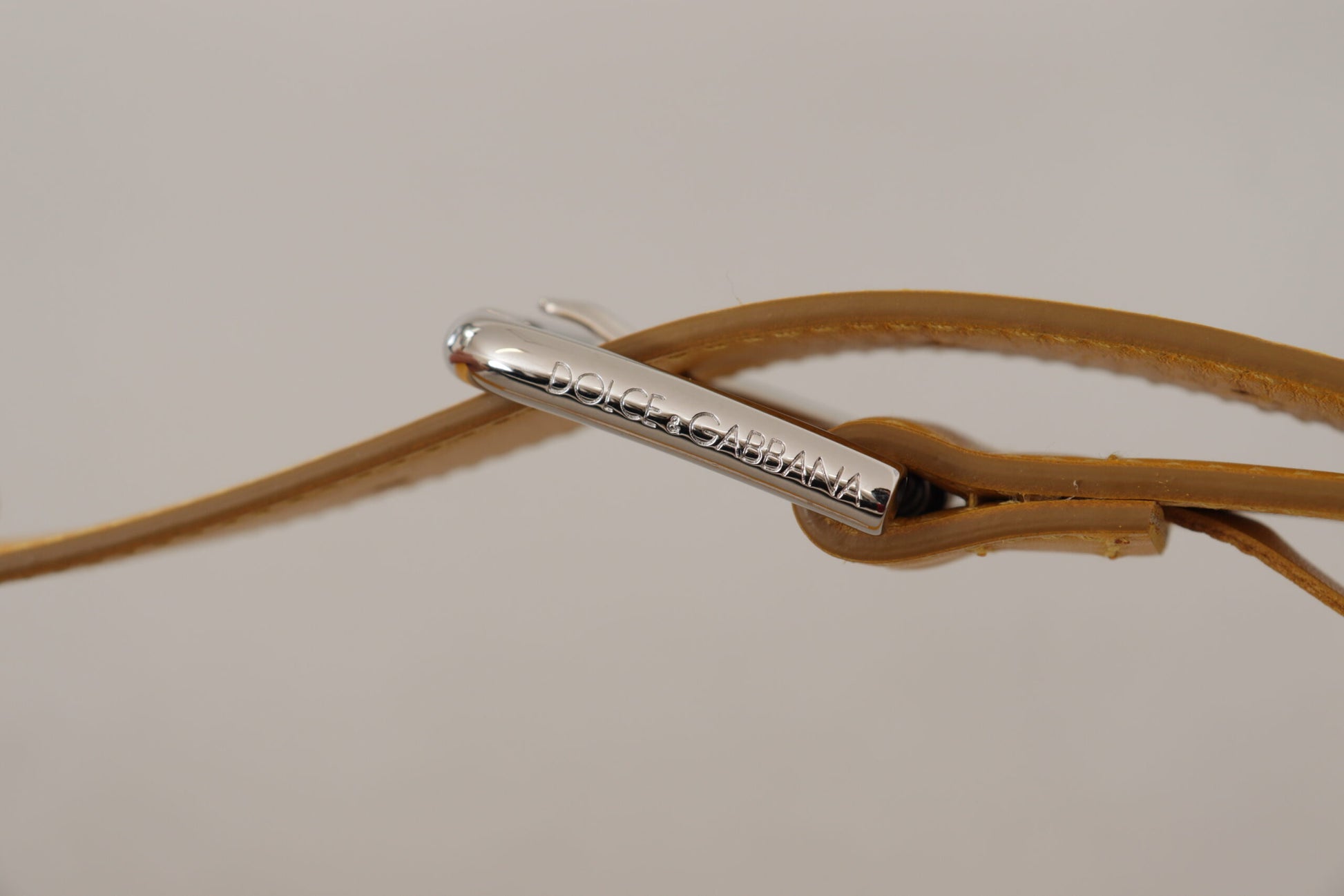 Ceinture en cuir jaune avec boucle en métal argenté et logo.