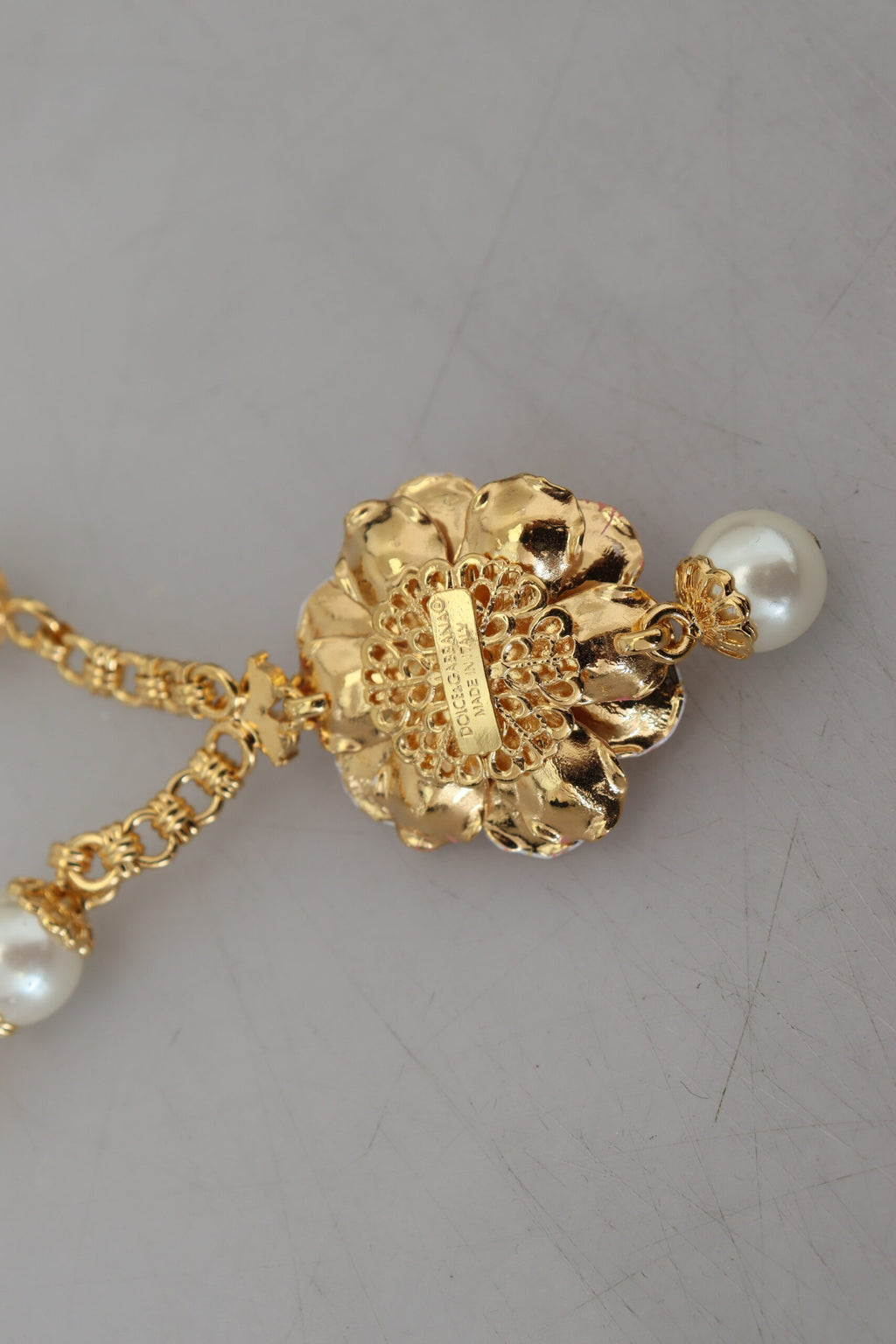Collier doré à motifs floraux, ornements roses et cristaux.