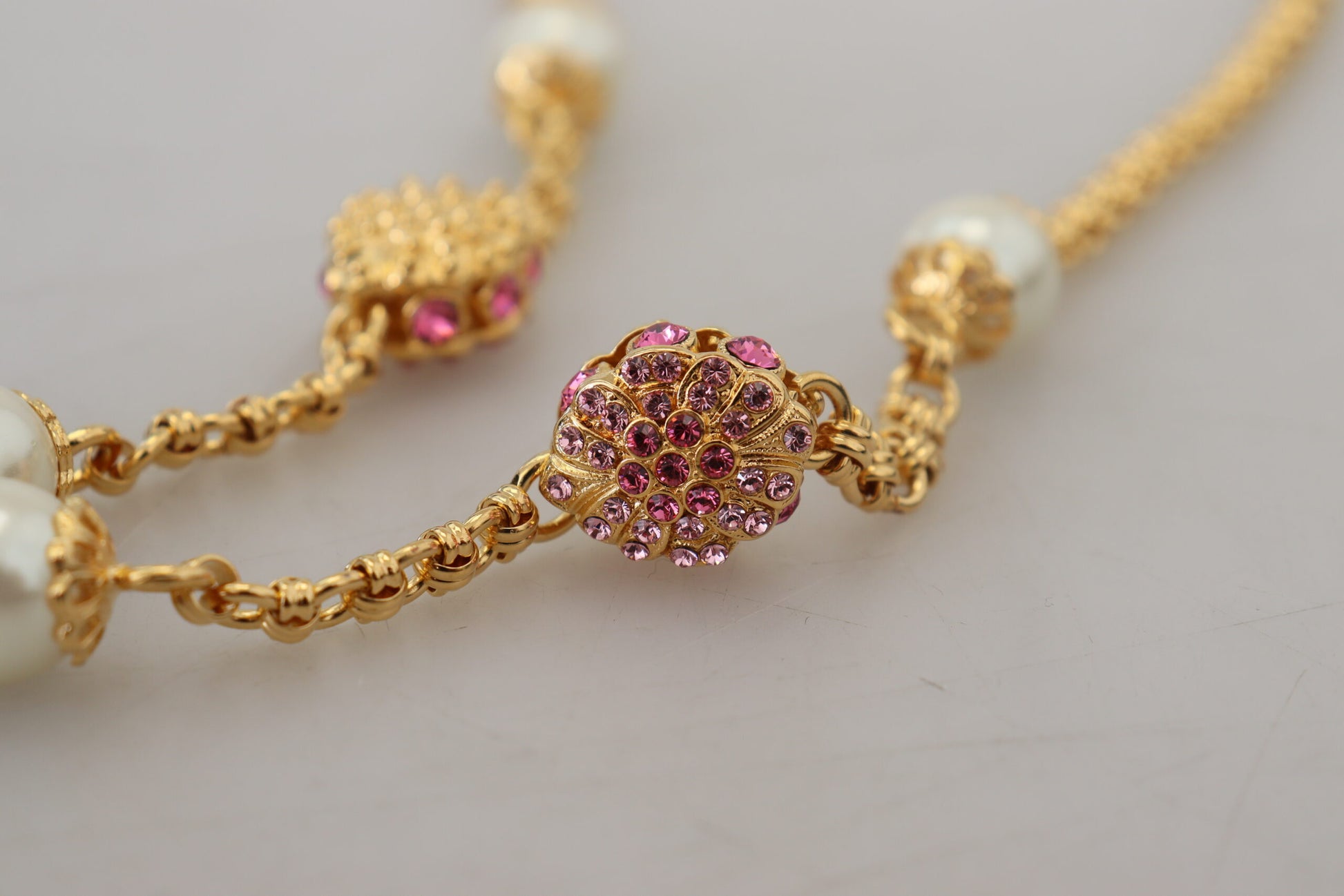 Collier doré à motifs floraux, ornements roses et cristaux.
