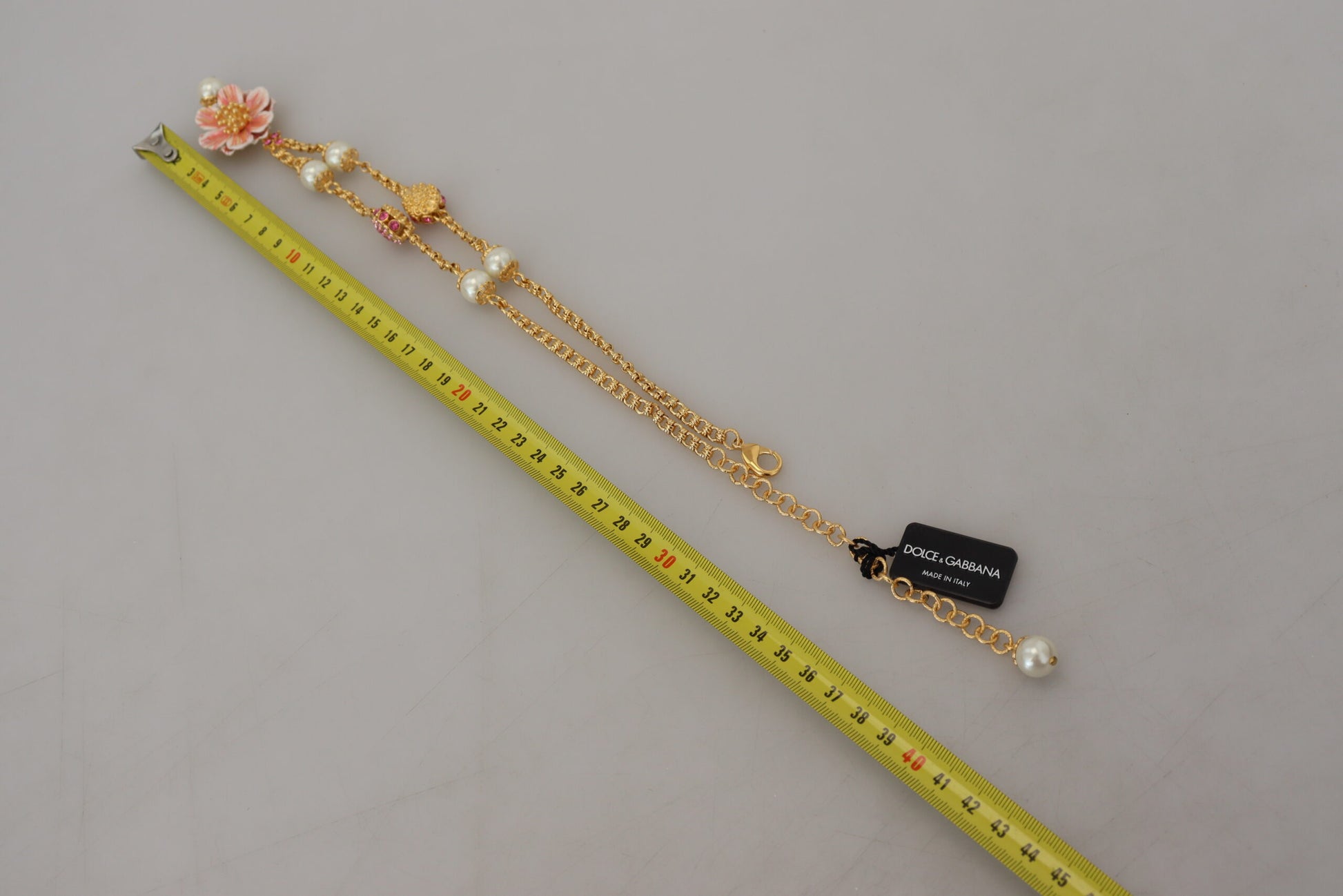 Collier doré à motifs floraux, ornements roses et cristaux.