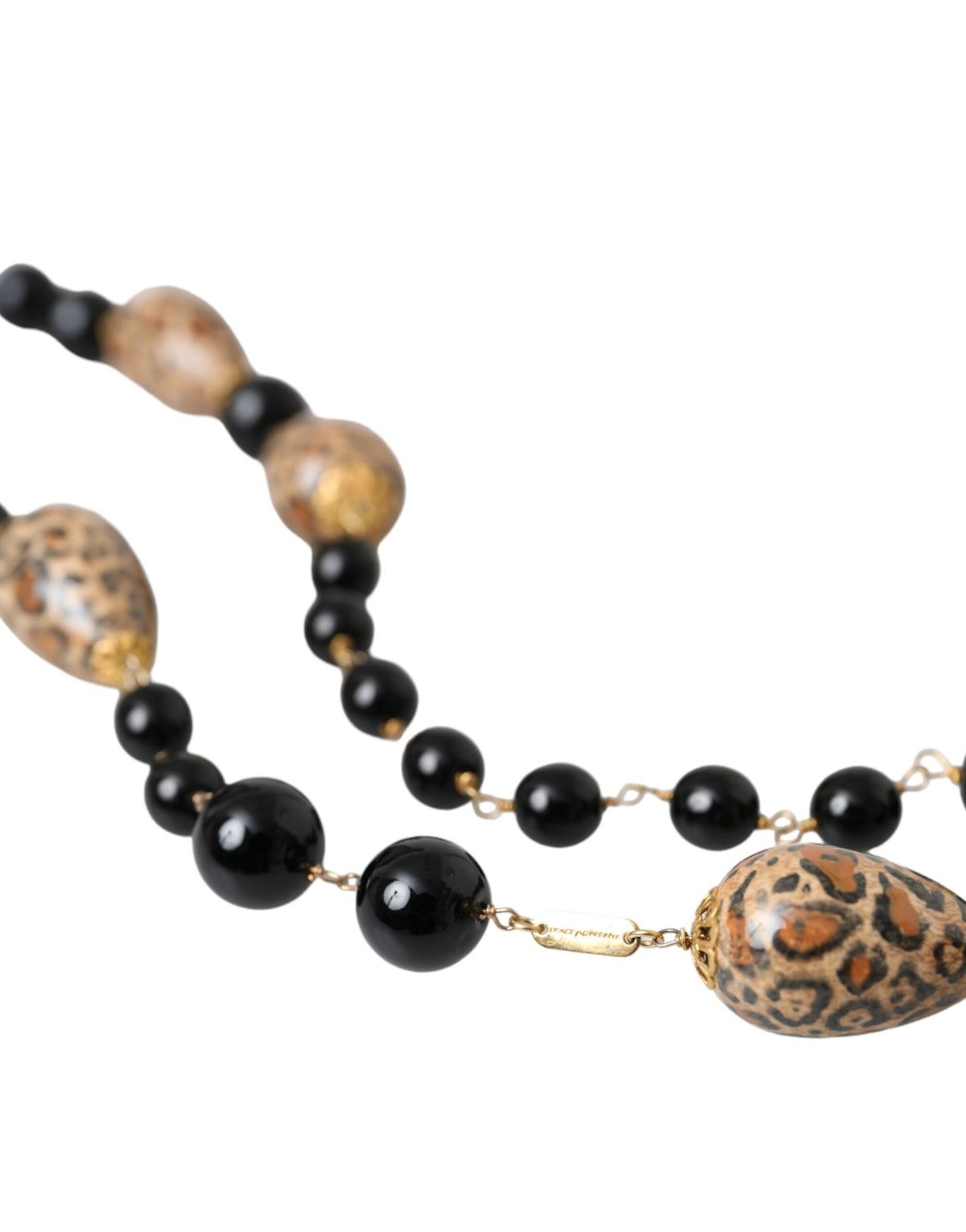 Collier long en laiton doré avec perles et imprimé noir.