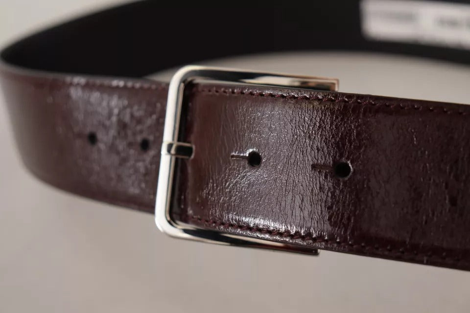 Ceinture en cuir marron foncé avec boucle en métal gravée du logo.