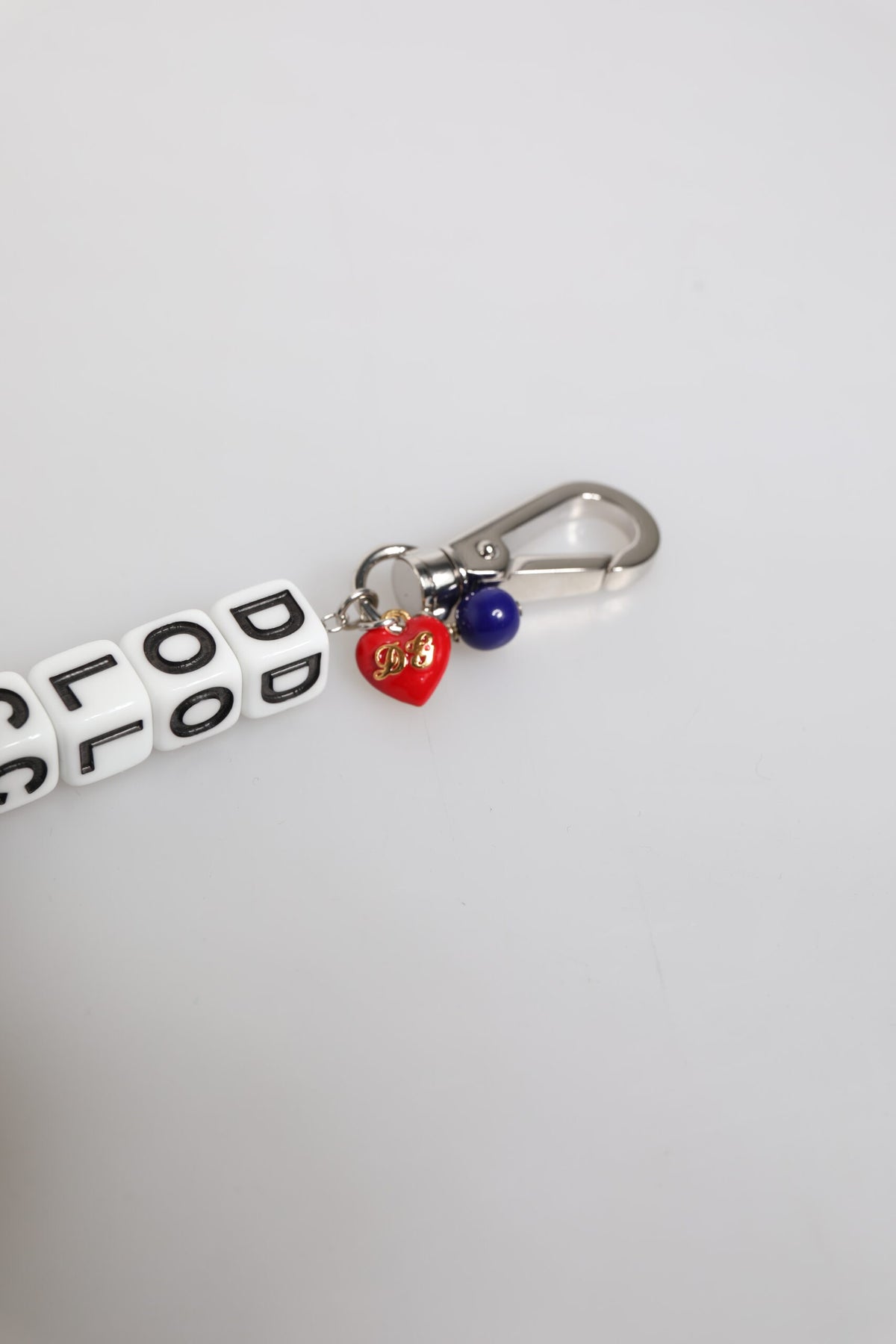 Bracelet en chaîne en laiton argenté avec logo et breloques décoratives.