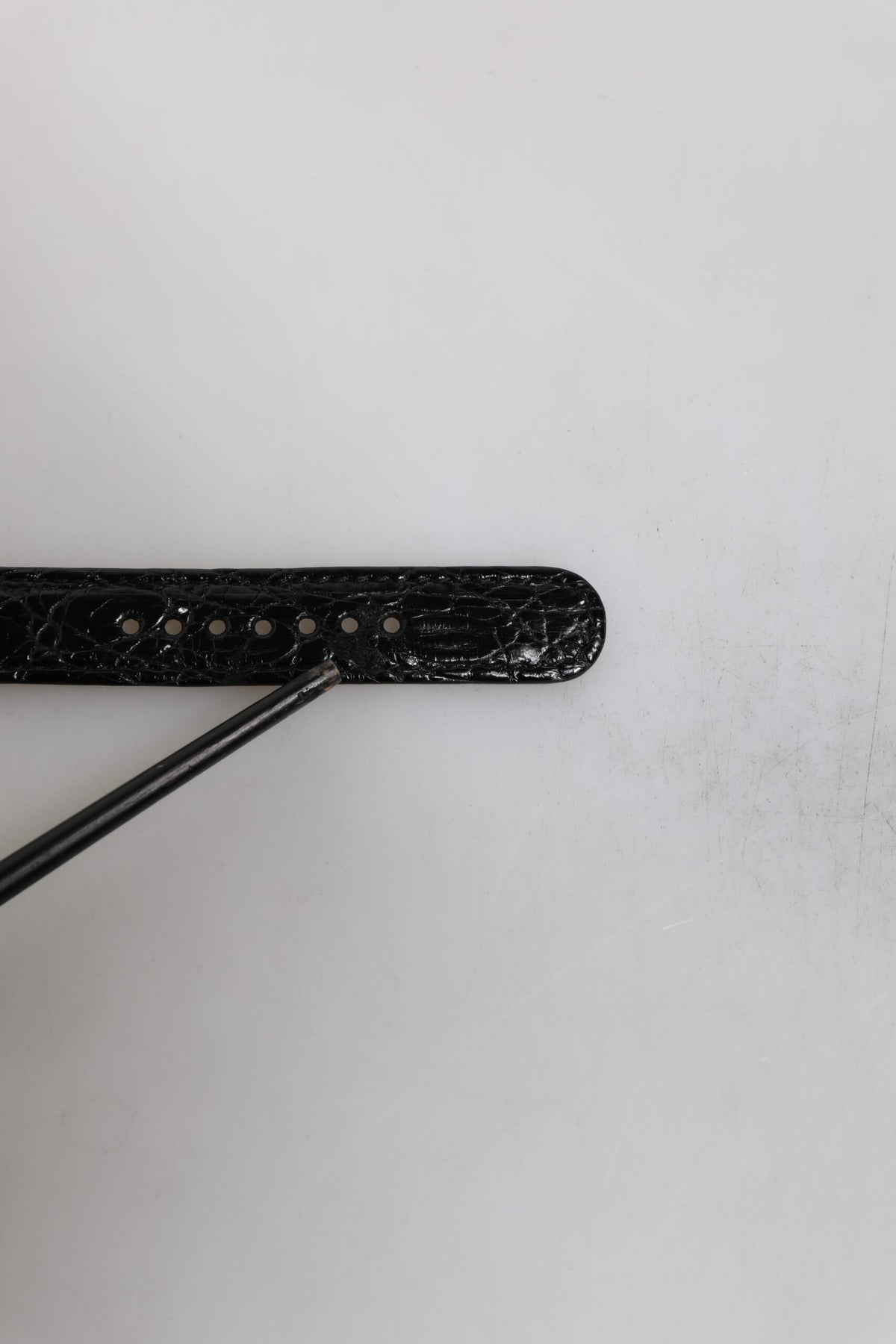 Bracelet en cuir exotique noir avec boucle en métal doré.