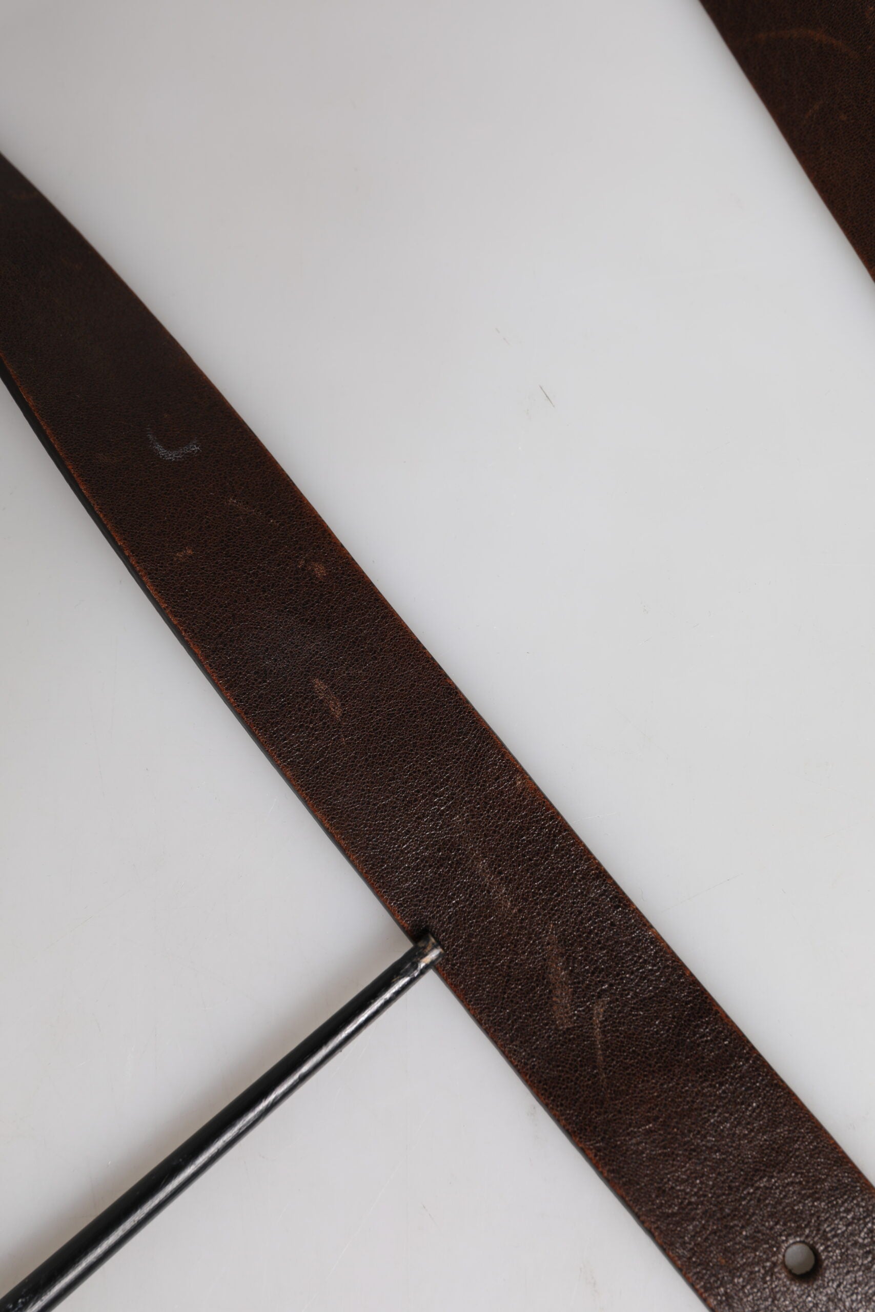 Ceinture en cuir marron avec boucle métallique classique et logo.