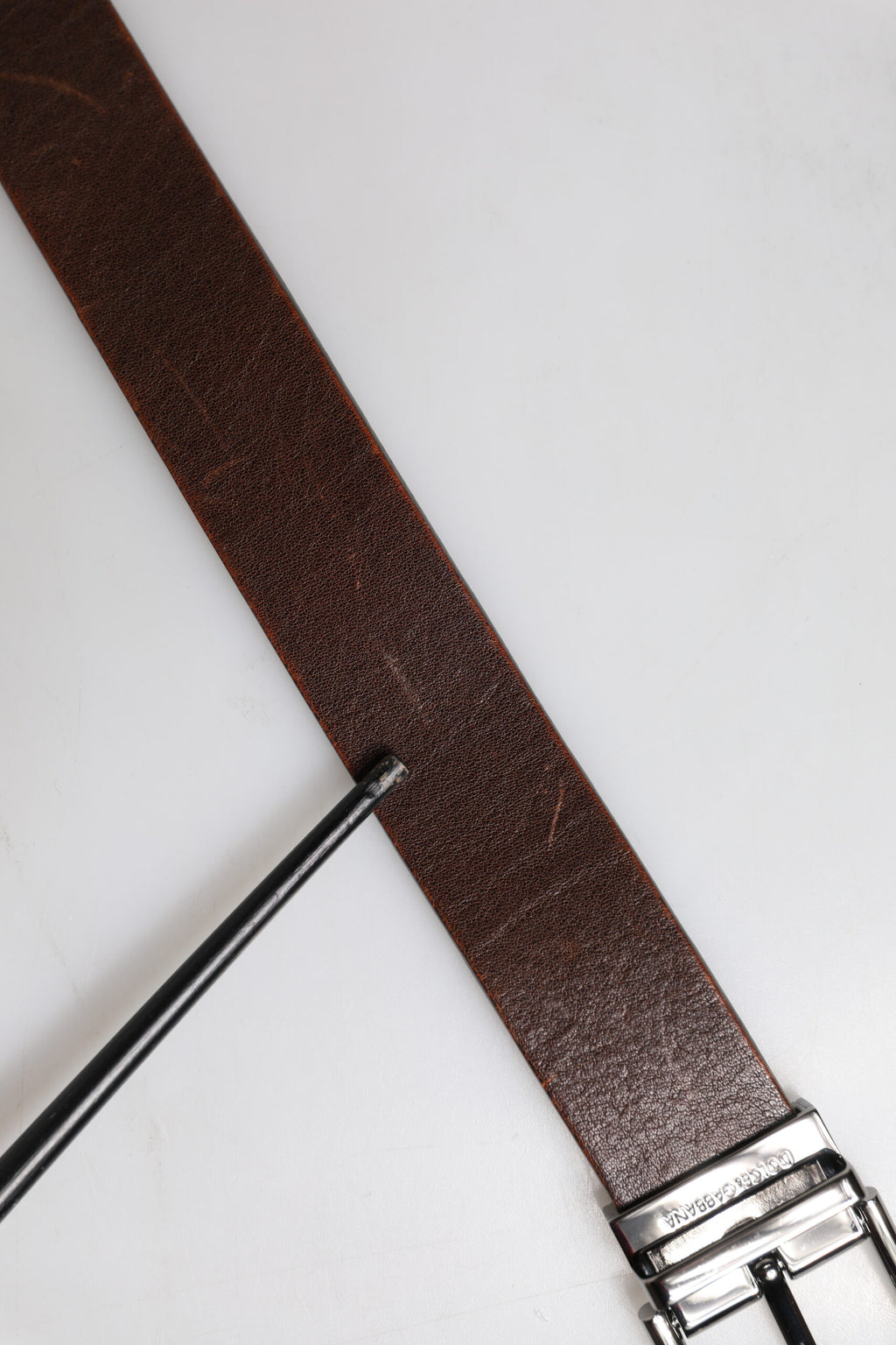 Ceinture en cuir marron avec boucle métallique classique et logo.