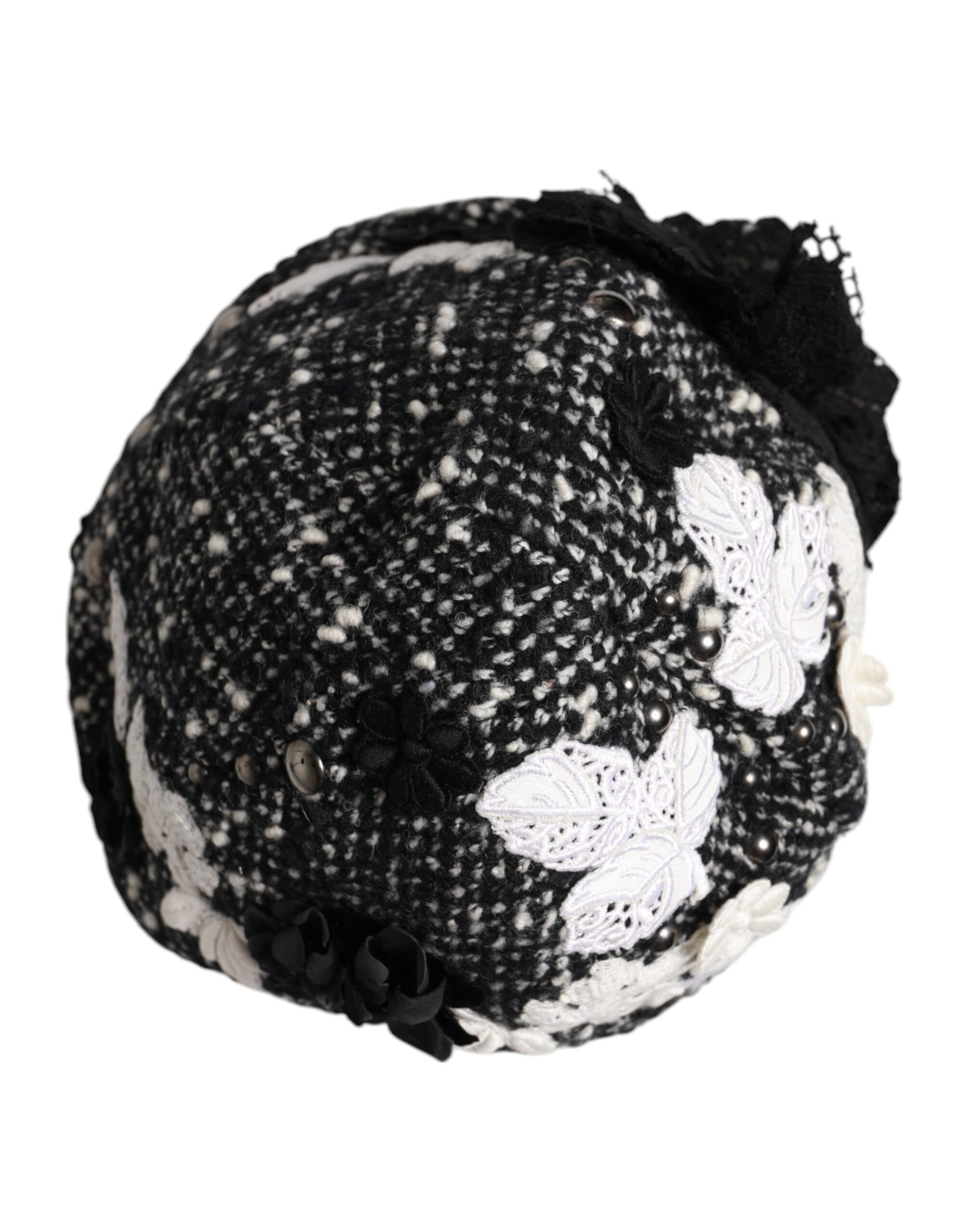 Chapeau cloche en laine noire avec décor floral blanc.