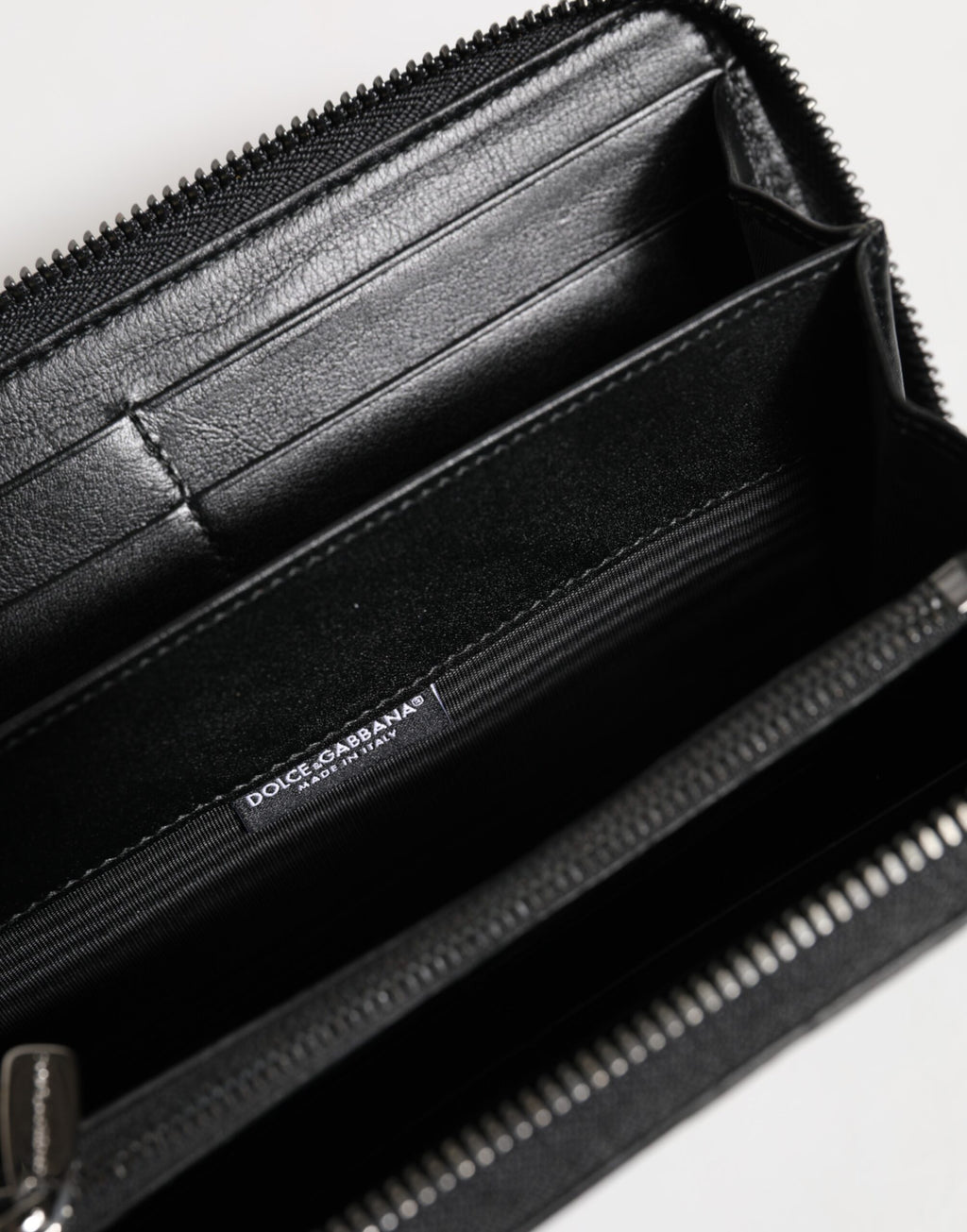 Portefeuille continental à fermeture éclair en cuir noir avec plaque de logo.