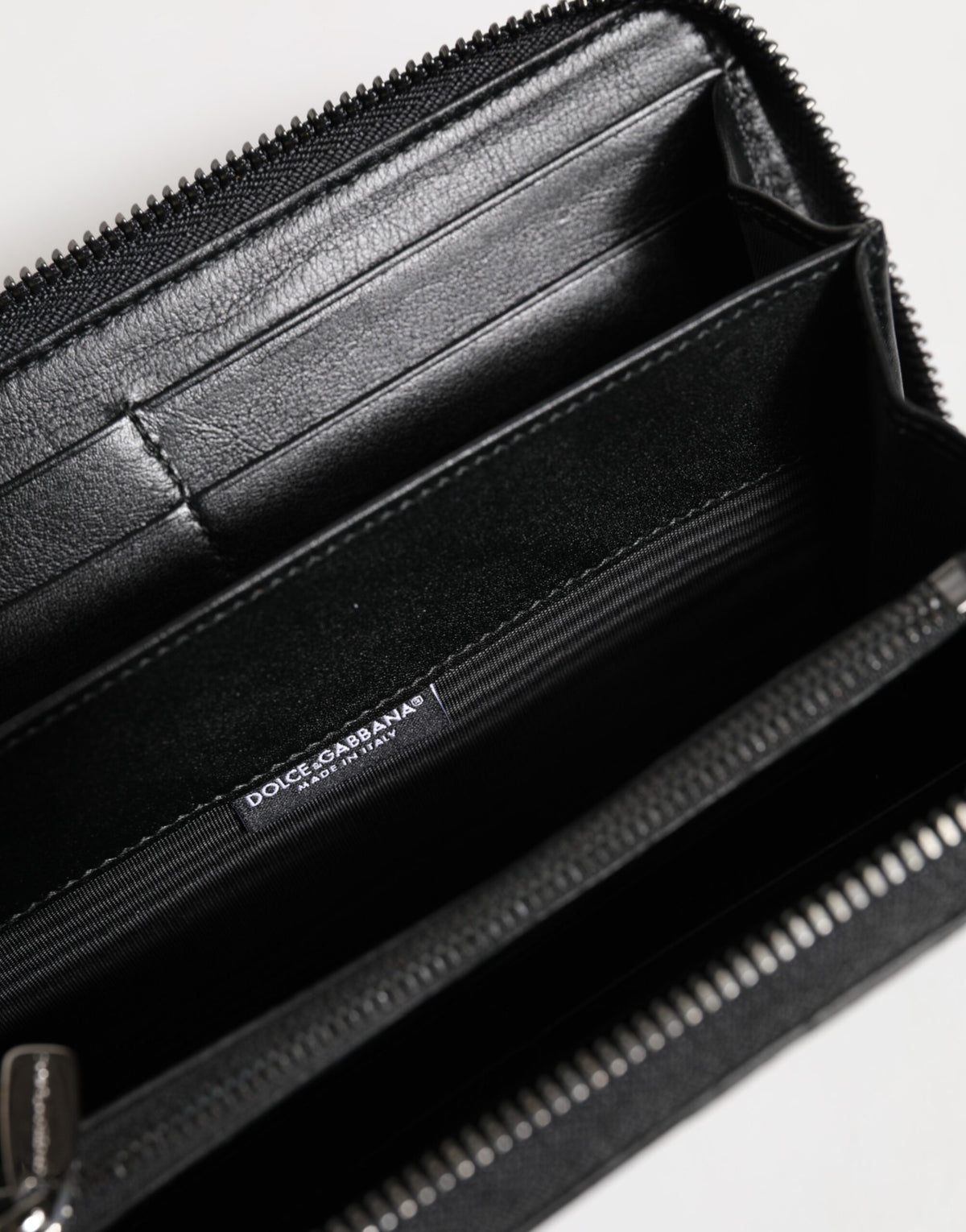 Portefeuille continental à fermeture éclair en cuir noir avec plaque de logo.