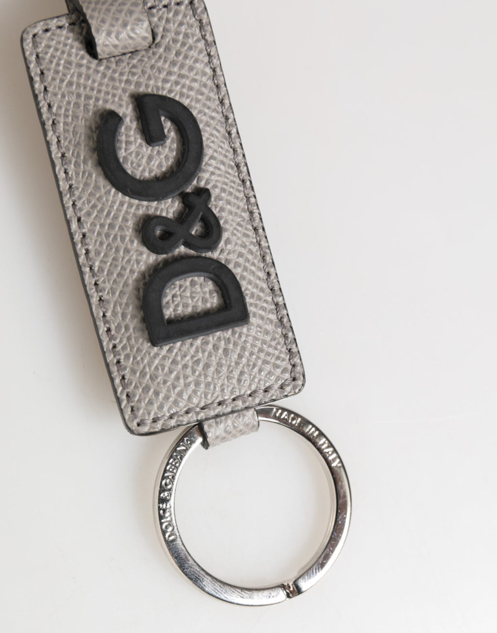 Porte-clés en cuir gris avec logo métallique et anneau pour homme.