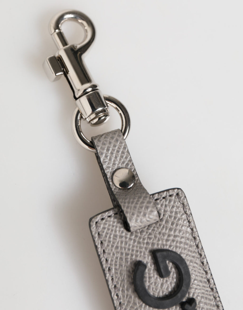 Porte-clés en cuir gris avec logo métallique et anneau pour homme.