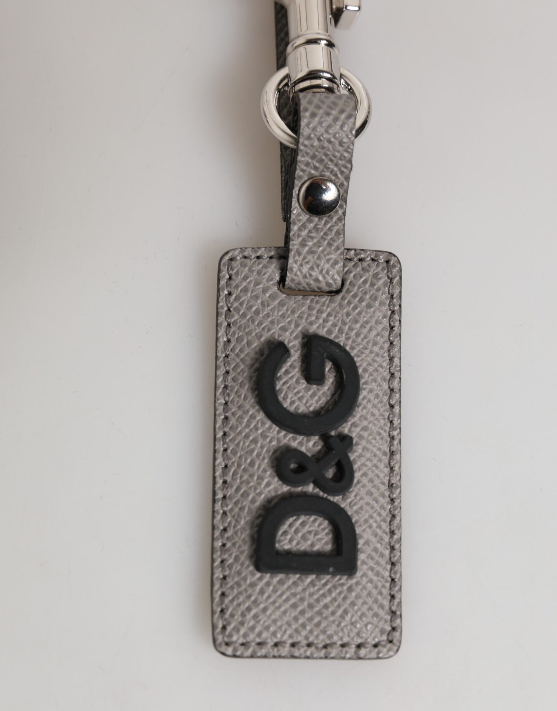 Porte-clés en cuir gris avec logo métallique et anneau pour hommes.