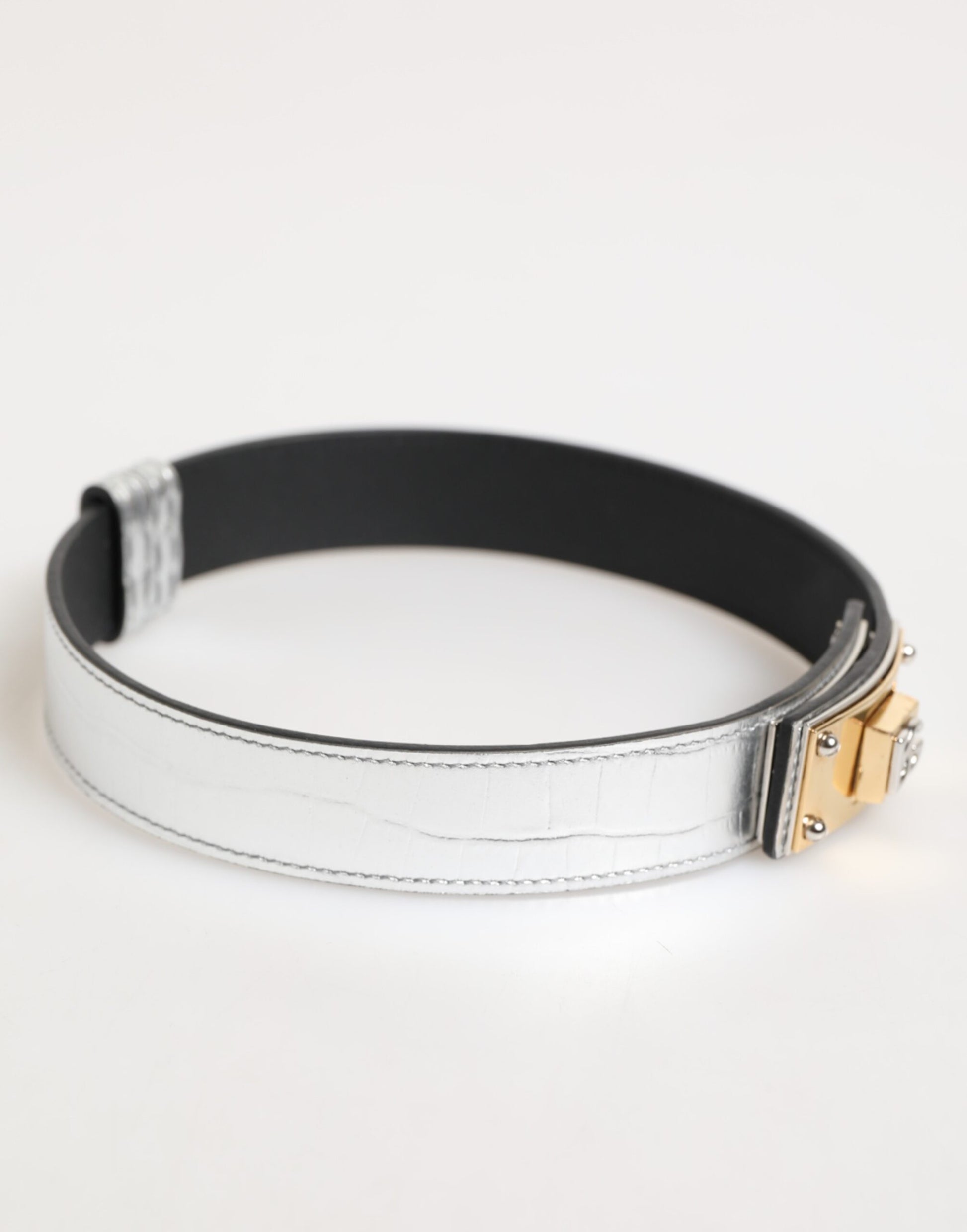 Collier en cuir texturé argenté avec détail métallique doré.
