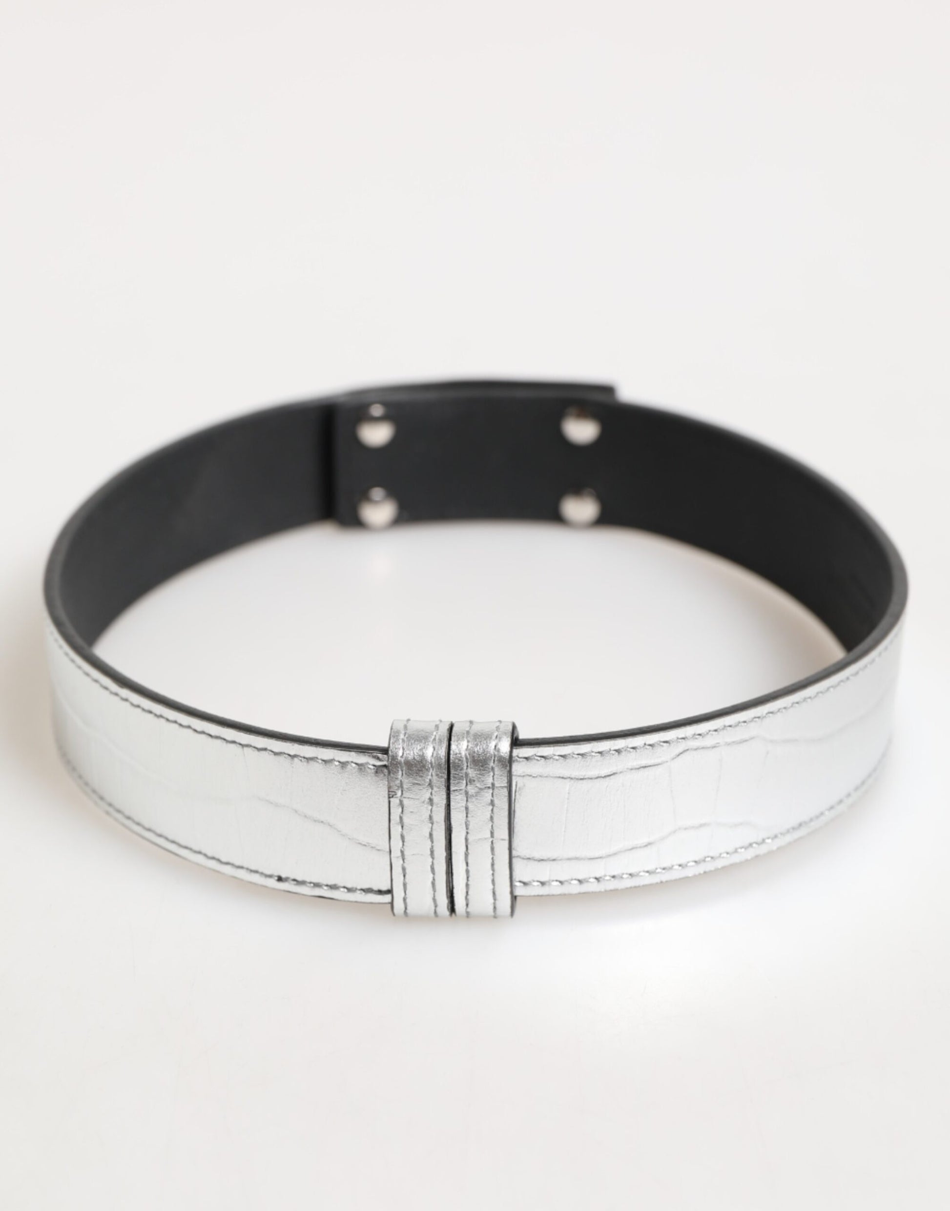 Collier en cuir texturé argenté avec détail métallique doré.