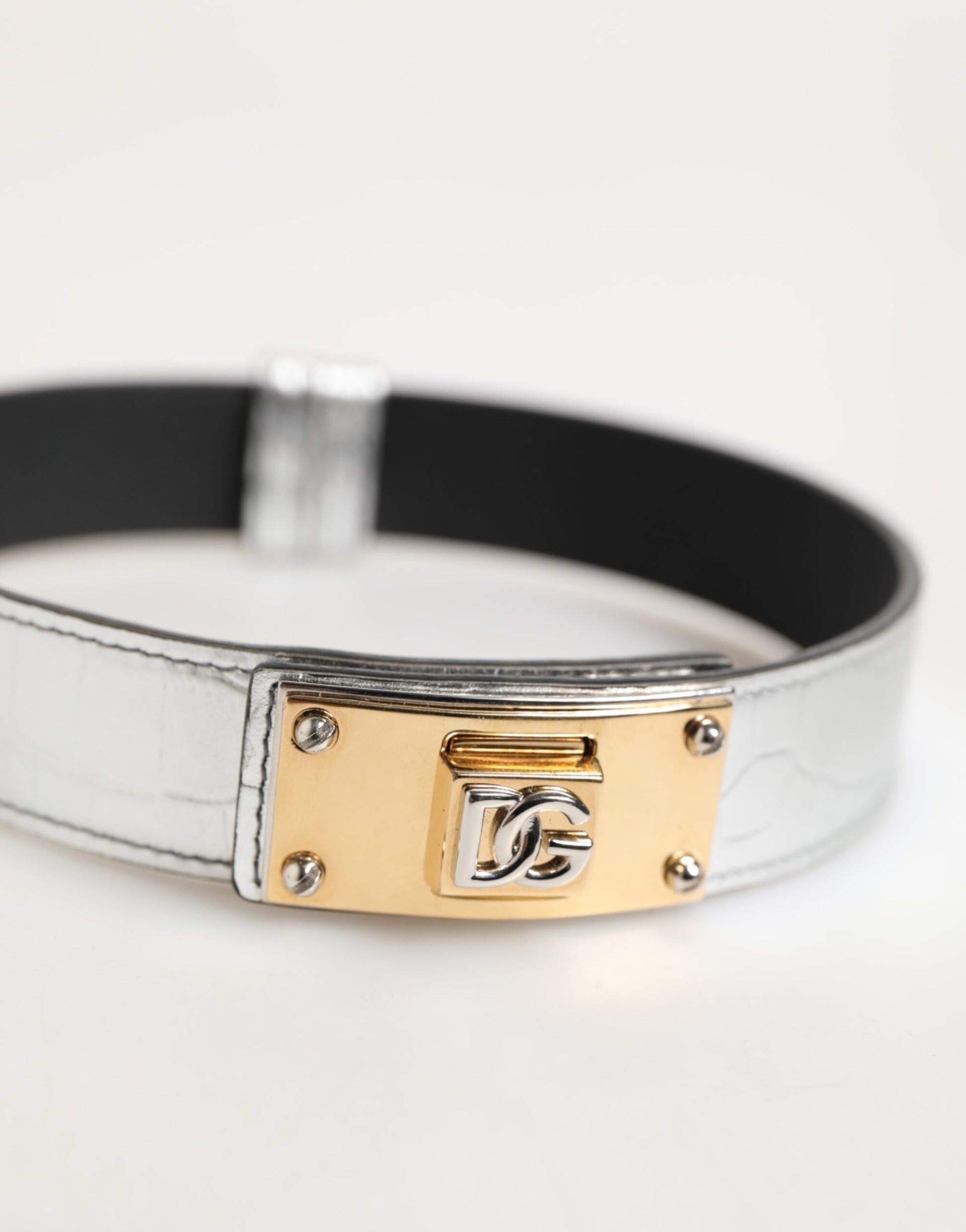 Collier en cuir texturé argenté avec détail métallique doré.