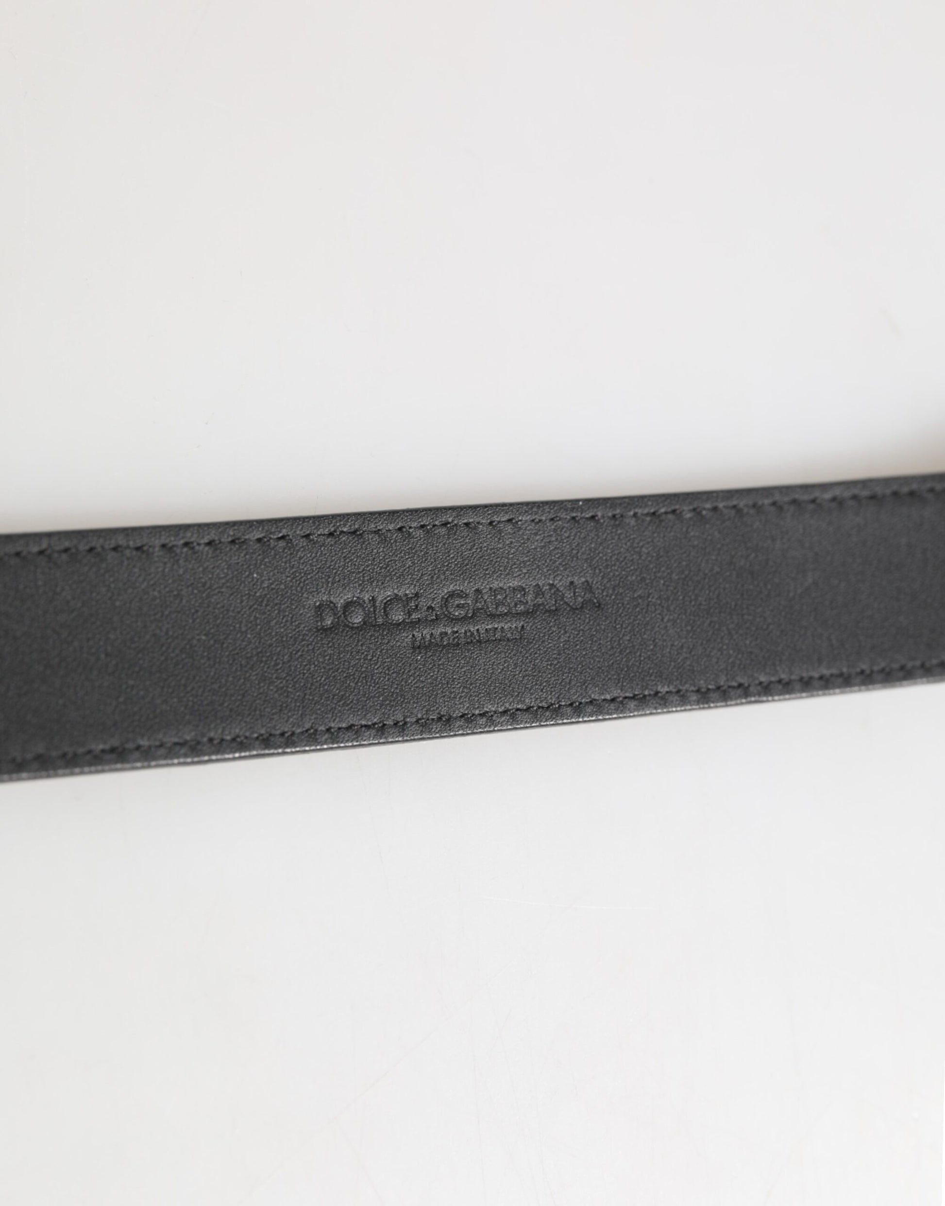 Collier en cuir texturé argenté avec détail métallique doré.