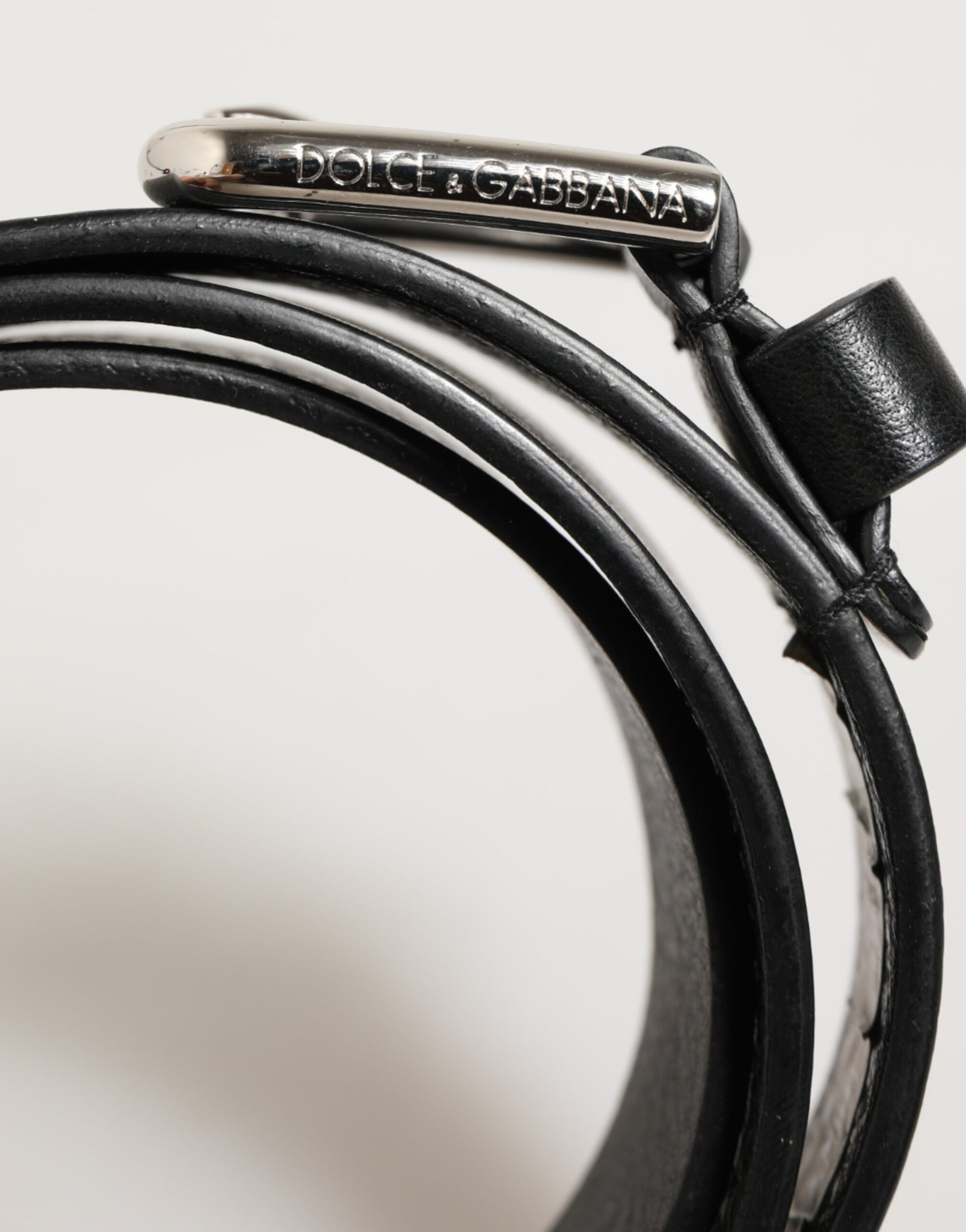 Ceinture en cuir noir classique avec boucle métallique et logo.
