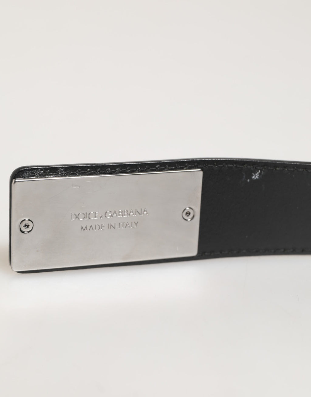 Ceinture en cuir noir classique avec boucle métallique et logo.