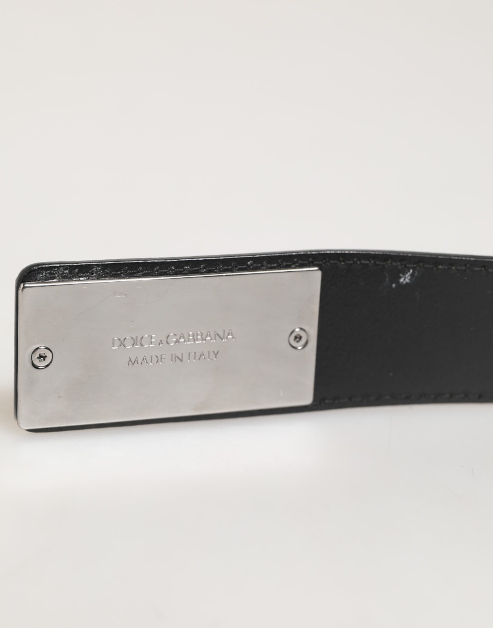 Ceinture en cuir noir classique avec boucle métallique et logo.